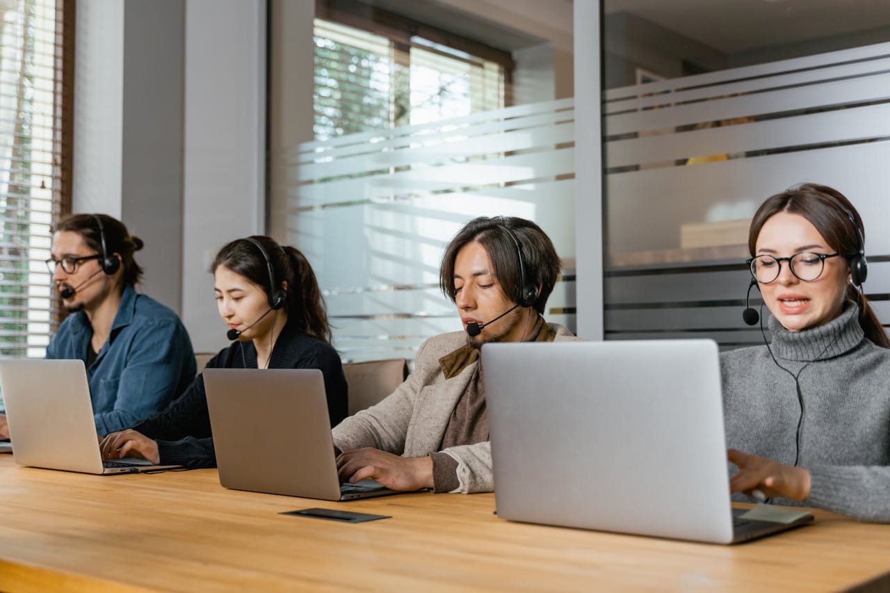 Home Four customer support agents working diligently in an office setting.