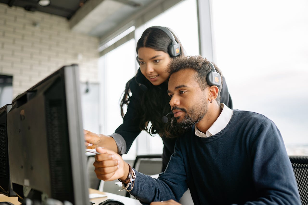 Home Two call center employees working together with headsets in a modern office setting.